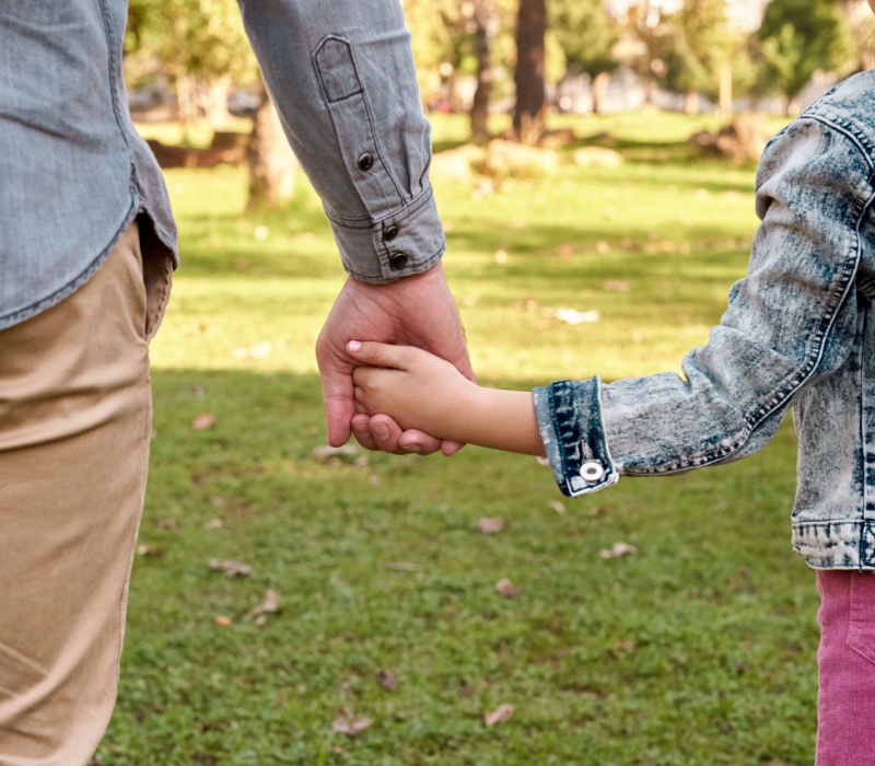 Parent and child holding hands.