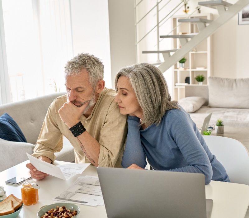 A couple looking at paperwork together in their home.