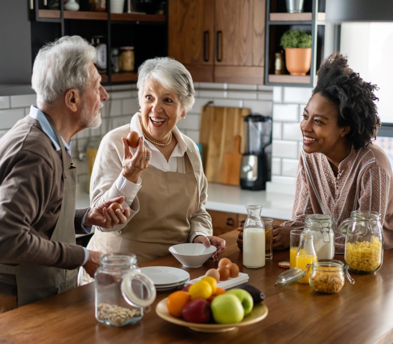 Parents talking to their adult child in their kitchen.